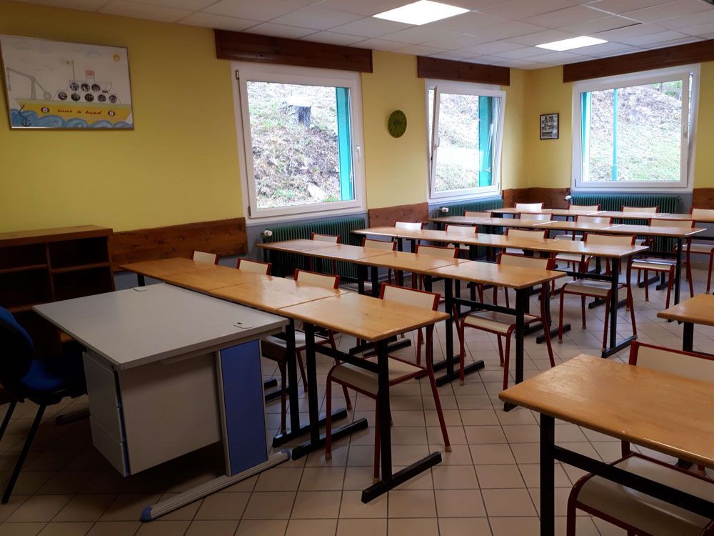Une salle de classe aveec des bureaux et chaises